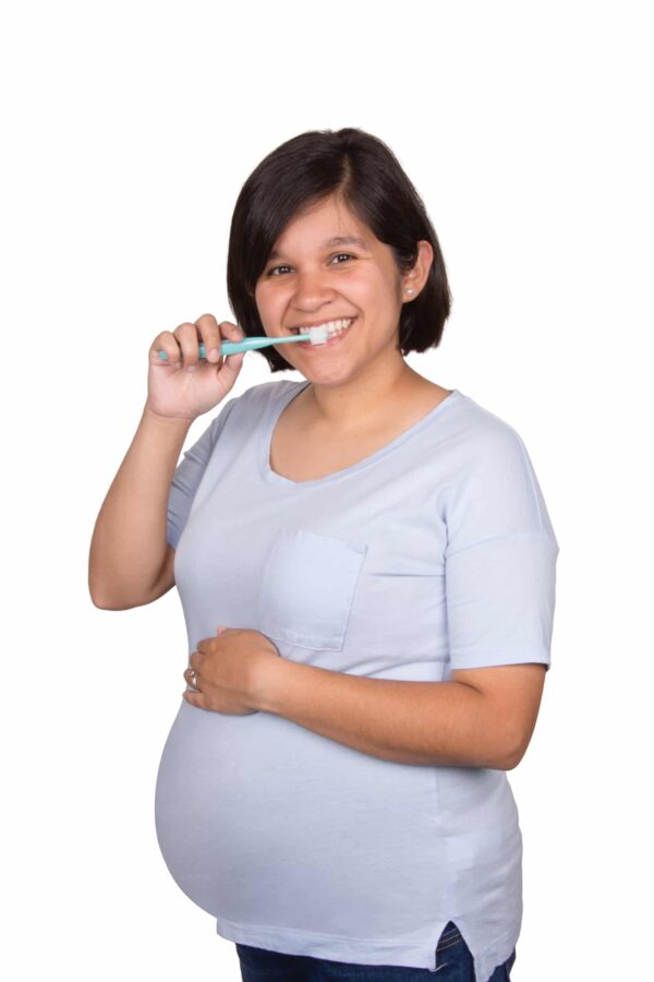 Pregnant Woman Using Green Brilliant Oral Care Round Toothbrush